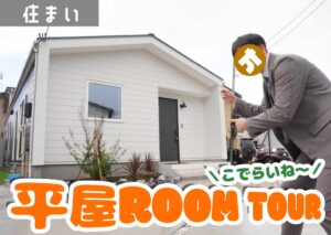 鶴岡市の平屋モデル住宅こでらいね外観を指さす編集部員