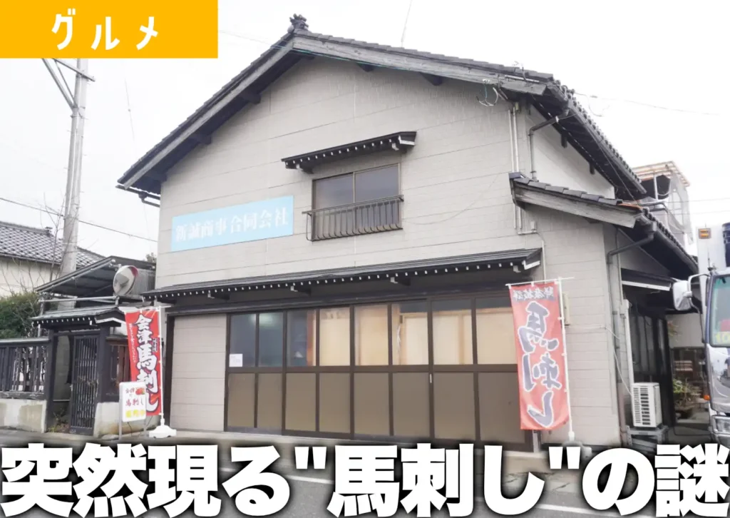 鶴岡市大淀川にある新誠商事の外観。表には会津馬刺しといったのぼり旗が見て取れる。